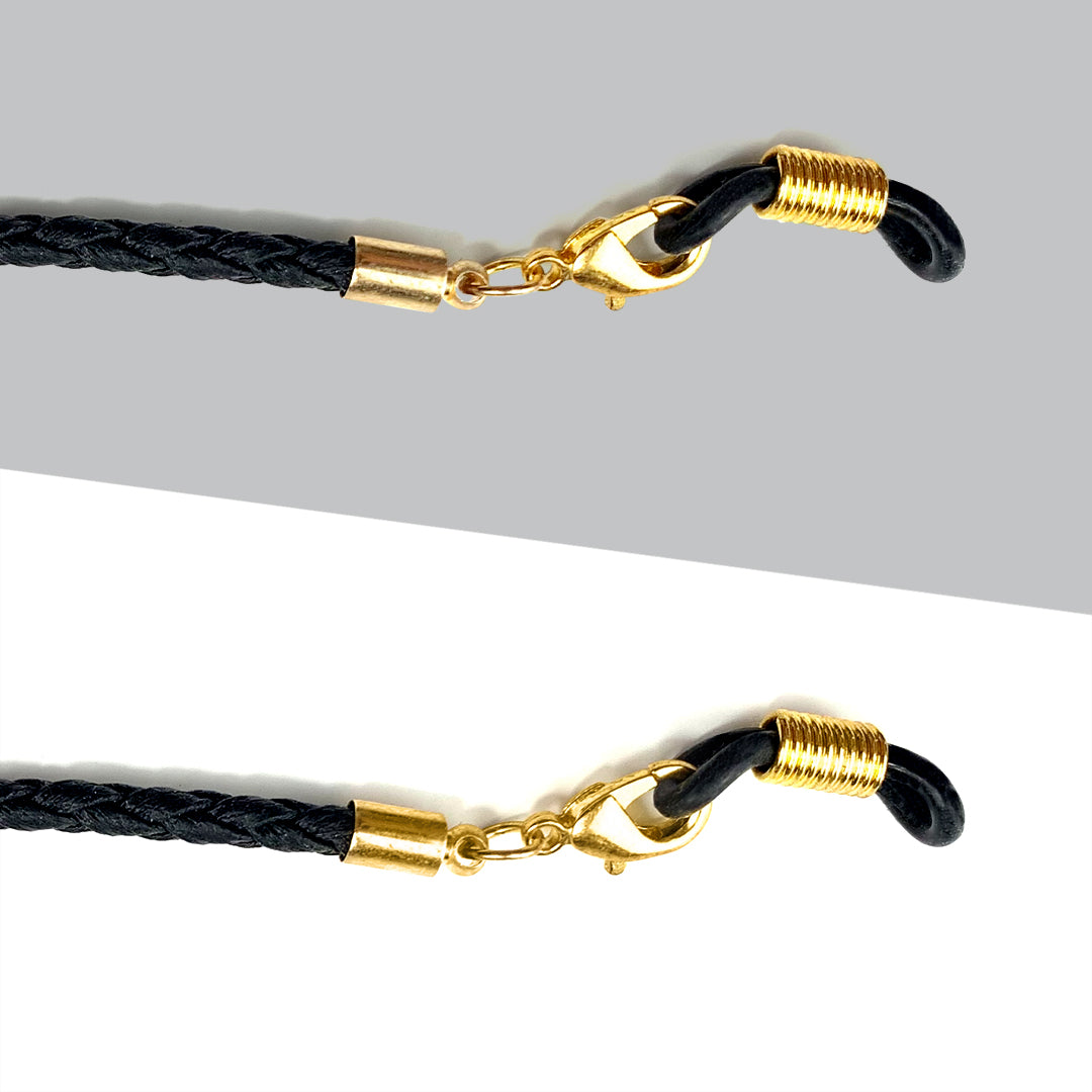 Black sunglass strap detail with gold hardware